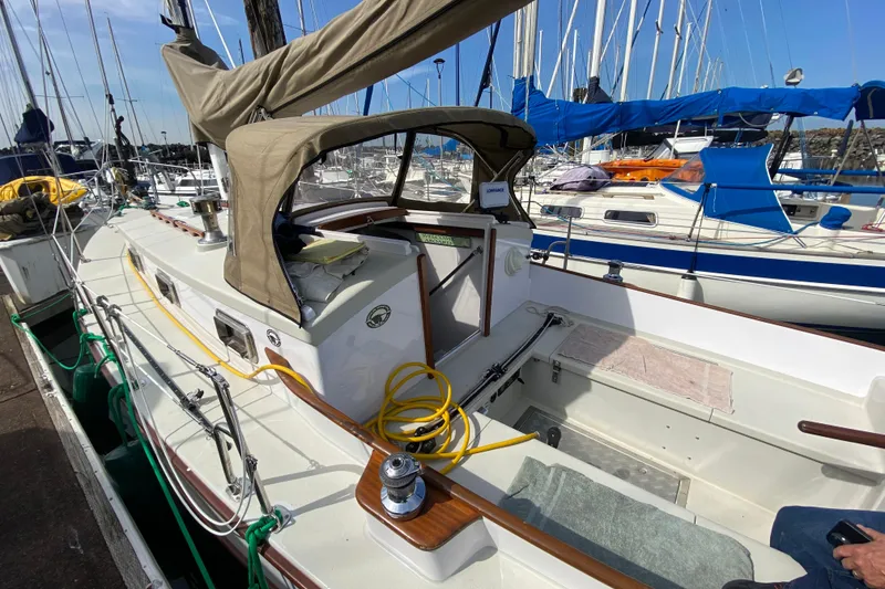 Slide: The Image of Sailboat docked in marina, Devlin Onyx 2013 model, featuring beige canopy and deck equipment. - 4