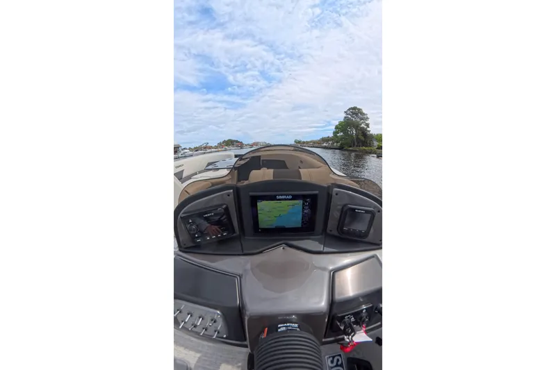 Slide: The Image of Dashboard view of a 2026 Coach 243 boat with navigation system on a sunny day. - 11