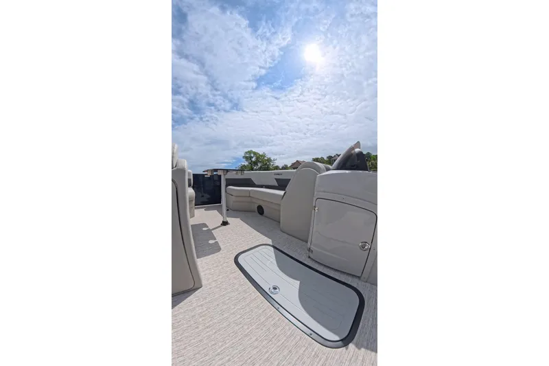 Slide: The Image of 2026 Coach 243 boat interior under sunny sky, featuring seating and storage compartments. - 14