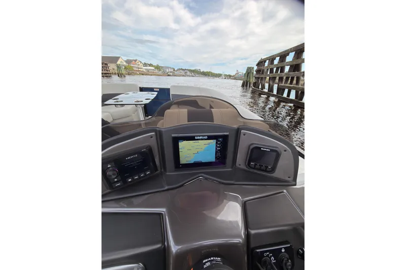 Slide: The Image of 2026 Coach 243 boat dashboard with navigation system on a scenic waterway. - 15