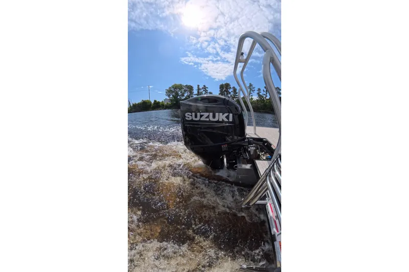 Slide: The Image of Boat with Suzuki outboard motor on water, sunny day, Coach model 243, year 2026. - 17