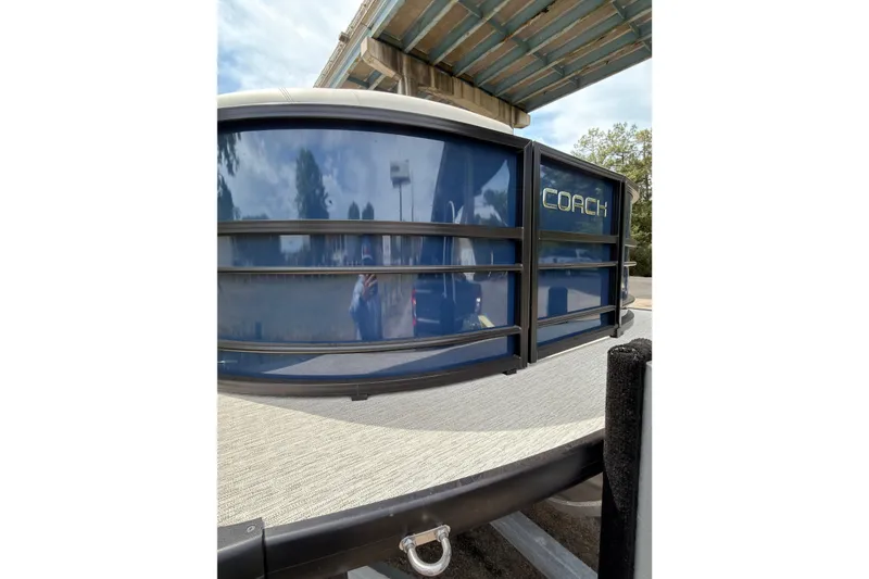 Slide: The Image of 2026 Coach 243 boat under a bridge, featuring sleek blue design and modern detailing. - 18