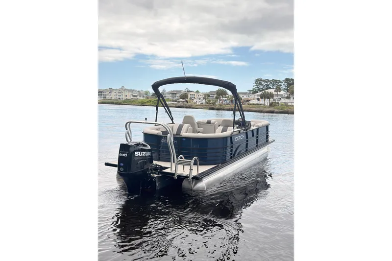 Slide: The Image of 2026 Coach Pontoons 243 RFC on water, featuring Suzuki outboard motor. - 2