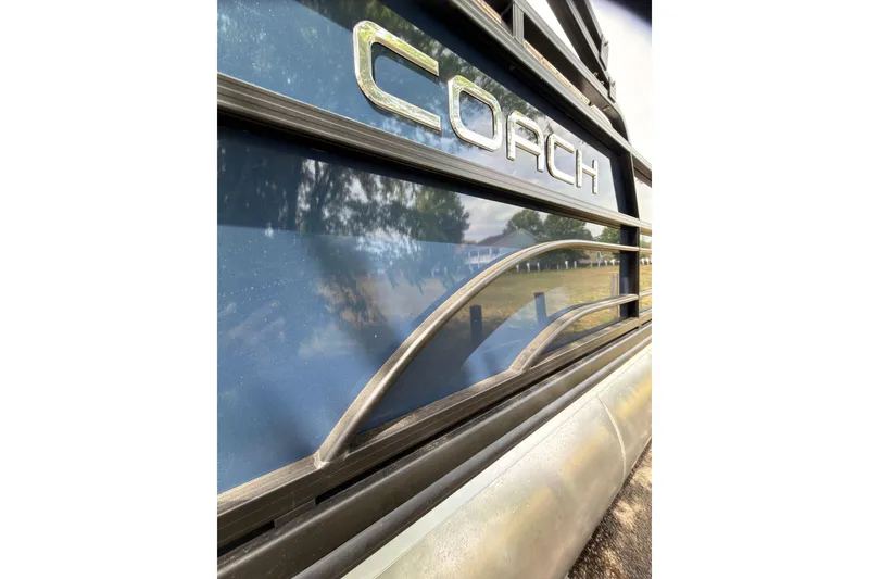 Slide: The Image of Close-up of 2026 Coach 243 boat exterior with reflective blue surface and metallic accents. - 22