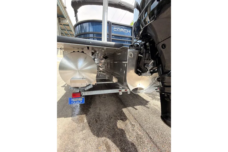 Slide: The Image of 2026 Coach 243 boat trailer with metallic components and visible license plate. - 25
