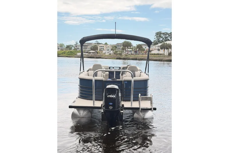 Slide: The Image of 2026 Coach Pontoons 243 RFC on water, rear view with motor and canopy. - 4