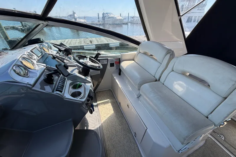 Slide: The Image of 2007 Monterey 330 Sport Yacht cockpit with steering wheel and white seating. - 18