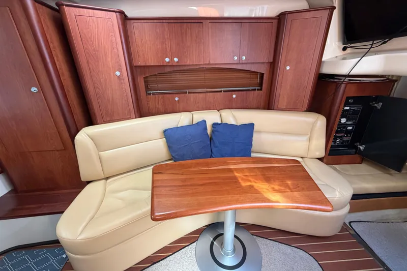 Slide: The Image of Interior of 2007 Monterey 330 Sport Yacht with beige seating and wooden table. - 28