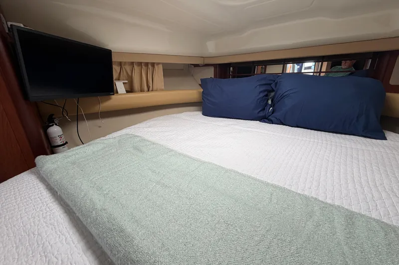 Slide: The Image of Cozy cabin interior of 2007 Monterey 330 Sport Yacht with bed, TV, and fire extinguisher. - 35
