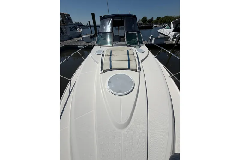 Slide: The Image of 2007 Monterey 330 Sport Yacht docked, showcasing sleek deck design and sunbathing area. - 7