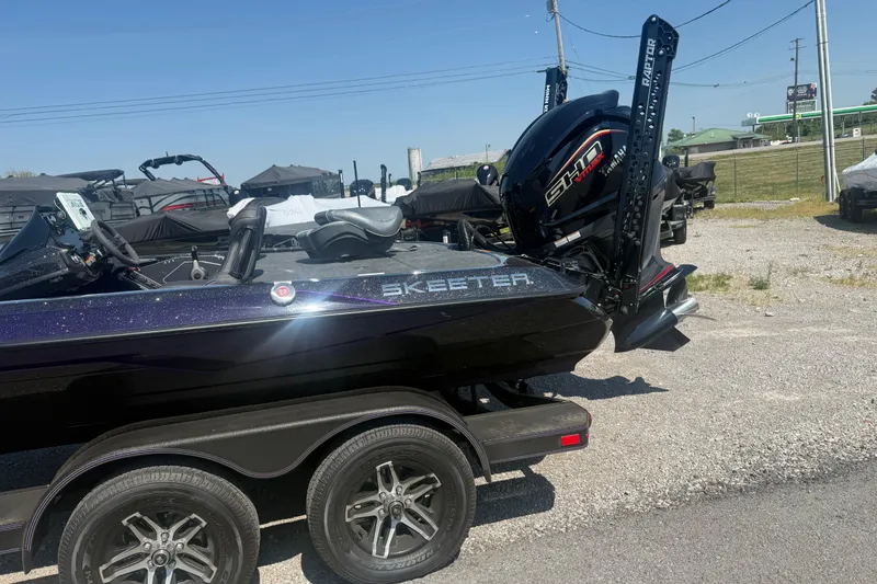 Slide: The Image of 2025 Skeeter ZXR21 boat with powerful engine on a trailer in a parking lot. - 5