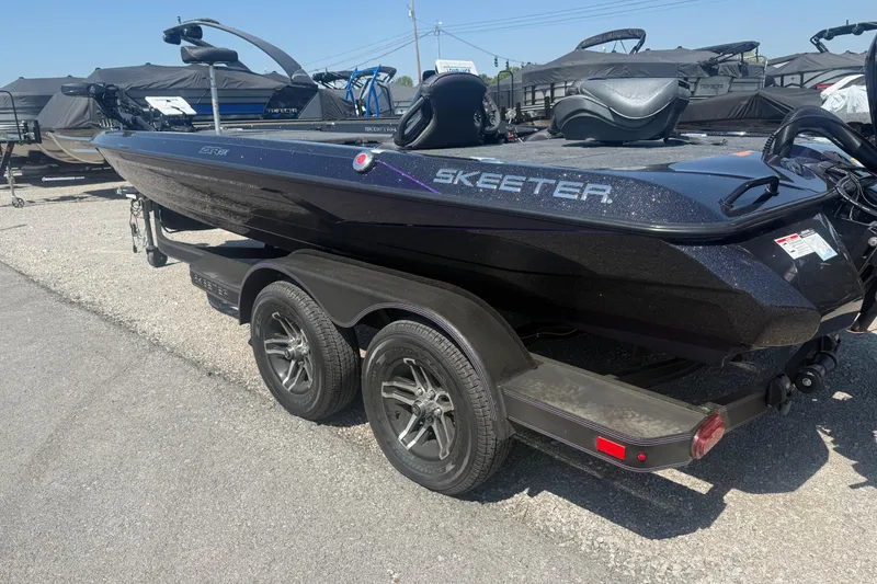 Slide: The Image of 2025 Skeeter ZXR21 boat on trailer, parked outdoors, showcasing sleek design and dual axles. - 6