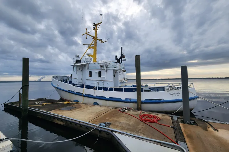 The Image of Docked 1960 Stord Verft model 60 boat under cloudy sky. - 0