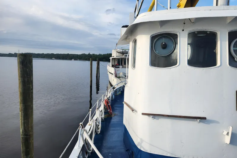 Slide: The Image of Vintage 1960 Stord Verft 60 boat docked on calm water under cloudy sky. - 15