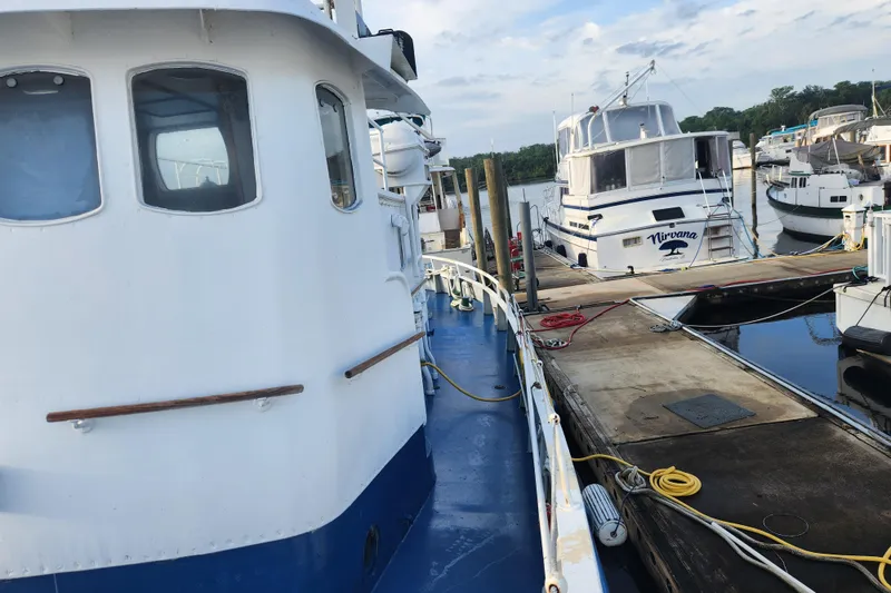 Slide: The Image of Docked Stord Verft 60 boat from 1960, with other vessels in a marina setting. - 16