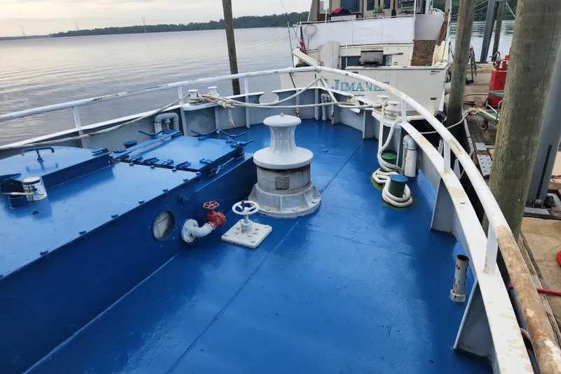 Slide: The Image of Blue deck of a 1960 Stord Verft 60 ship docked by the water. - 20