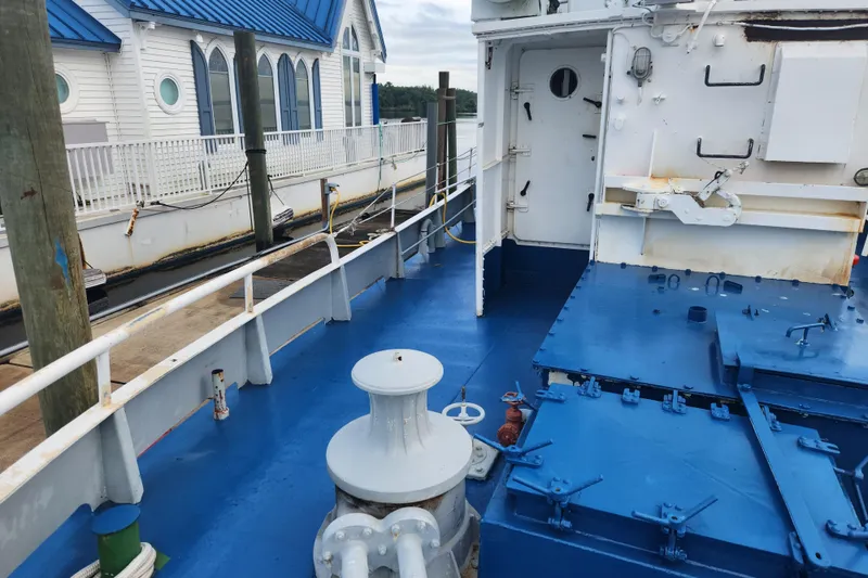 Slide: The Image of Deck of a 1960 Stord Verft 60 ship docked near a building with blue roof. - 24