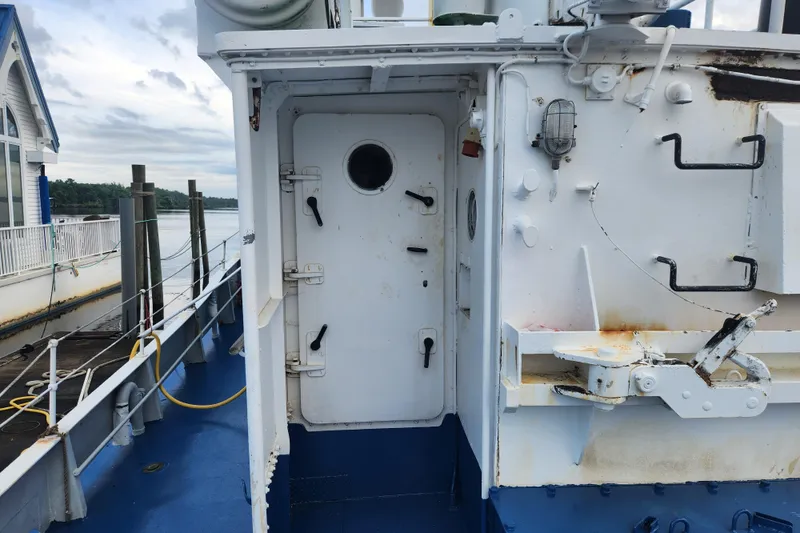 Slide: The Image of Exterior view of a 1960 Stord Verft 60 ship, featuring a white door and nautical equipment. - 29