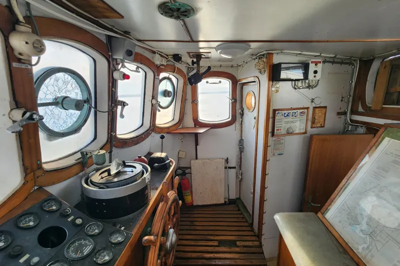 Slide: The Image of Interior of a 1960 Stord Verft 60 boat, featuring vintage navigation equipment and wooden accents. - 43