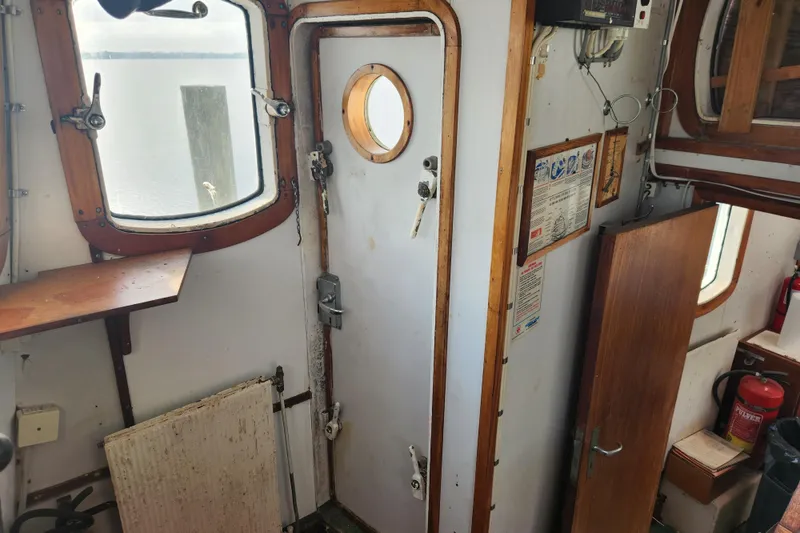 Slide: The Image of Interior of a 1960 Stord Verft 60 boat, featuring wooden accents and nautical equipment. - 46