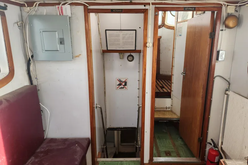 Slide: The Image of Interior of a 1960 Stord Verft model 60 boat, featuring seating and wooden doors. - 51