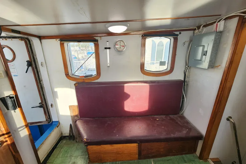 Slide: The Image of Interior of a 1960 Stord Verft 60 boat with maroon seating and wooden accents. - 52