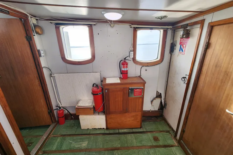 Slide: The Image of Interior of a 1960 Stord Verft 60 ship with wooden paneling and fire extinguishers. - 53