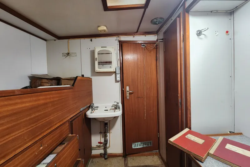 Slide: The Image of Interior of a 1960 Stord Verft model 60 ship, featuring wooden cabinetry and a small sink. - 58
