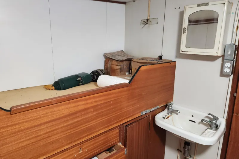 Slide: The Image of Interior of a 1960 Stord Verft 60, featuring a wooden cabinet and small sink. - 61
