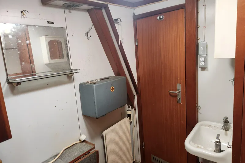 Slide: The Image of Small vintage bathroom with wooden door, mirror, sink, and electrical panel, Stord Verft 1960 model. - 67