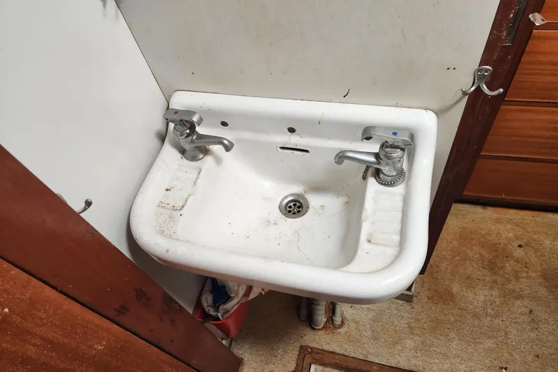 Slide: The Image of Vintage 1960 Stord Verft sink with dual faucets in a compact bathroom setting. - 68
