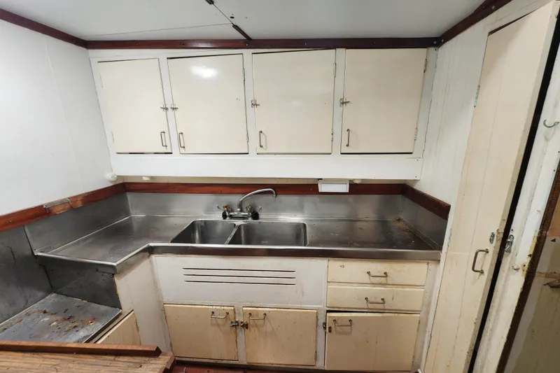 Slide: The Image of Vintage 1960 Stord Verft ship kitchen with stainless steel sink and storage cabinets. - 72