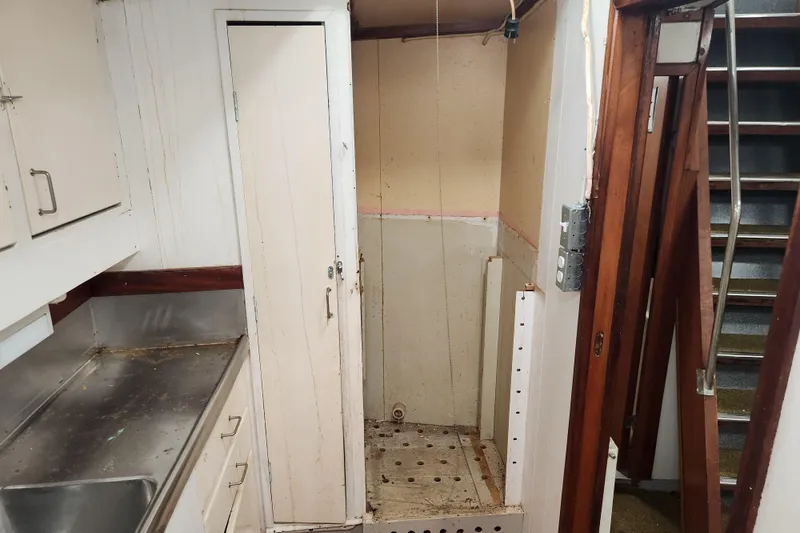Slide: The Image of Interior of a vintage 1960 Stord Verft 60 ship, featuring a small kitchenette and staircase. - 74