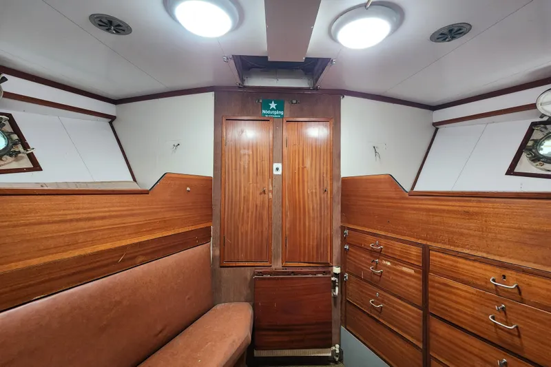 Slide: The Image of Interior of a 1960 Stord Verft 60 boat, featuring wooden cabinetry and seating. - 75