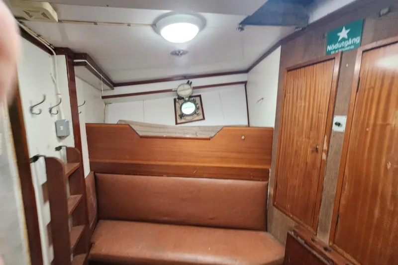 Slide: The Image of Interior of a 1960 Stord Verft 60 boat with wooden paneling and seating. - 76