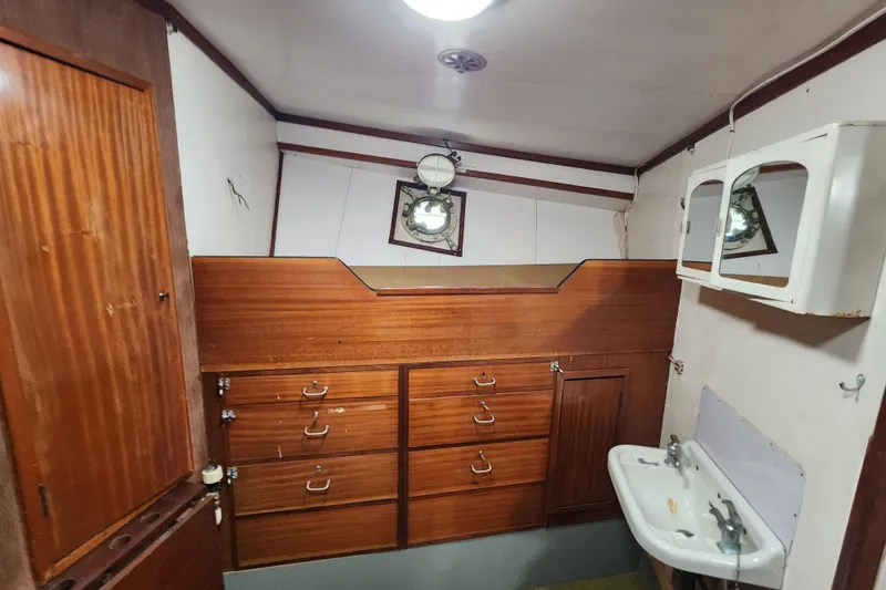 Slide: The Image of Interior of a 1960 Stord Verft 60 boat with wooden cabinetry and a small sink. - 77