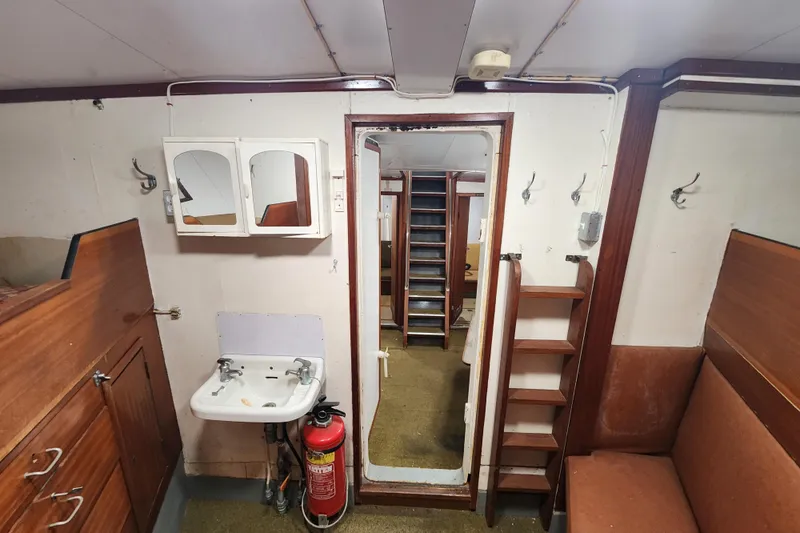 Slide: The Image of Interior of a 1960 Stord Verft 60 ship, featuring a sink, mirror, and fire extinguisher. - 78