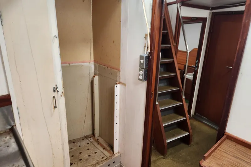 Slide: The Image of Interior of a 1960 Stord Verft 60 boat, featuring stairs and a small compartment. - 79