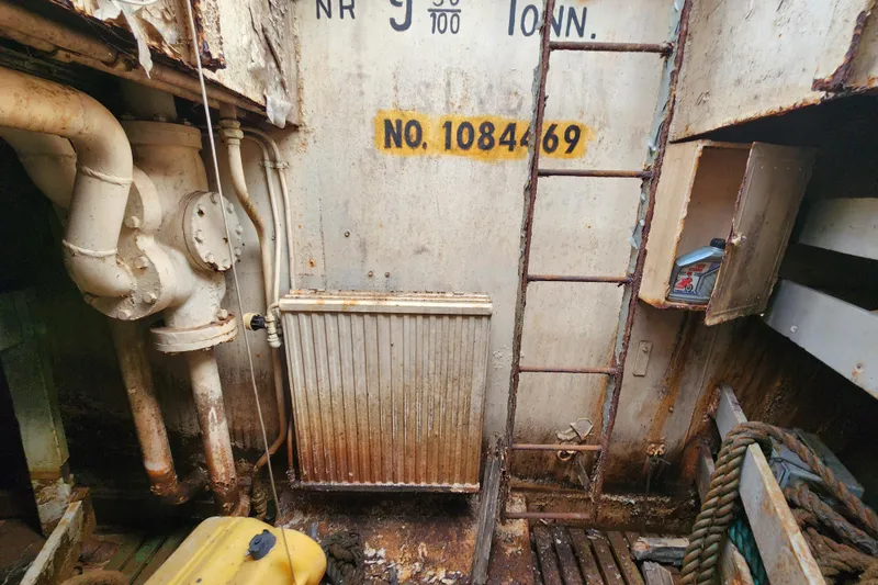 Slide: The Image of Rusty interior of a 1960 Stord Verft model 60 ship, featuring pipes and a ladder. - 88