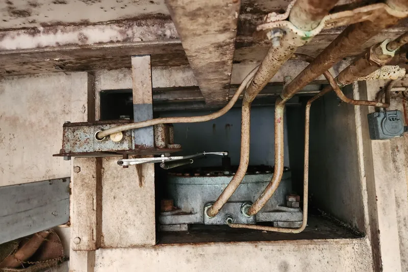 Slide: The Image of Rusty mechanical components of a 1960 Stord Verft model 60, featuring pipes and metal structures. - 89