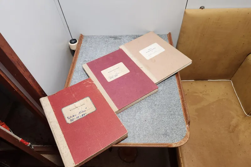 Slide: The Image of Three vintage notebooks on a small table inside a 1960 Stord Verft 60 boat. - 93