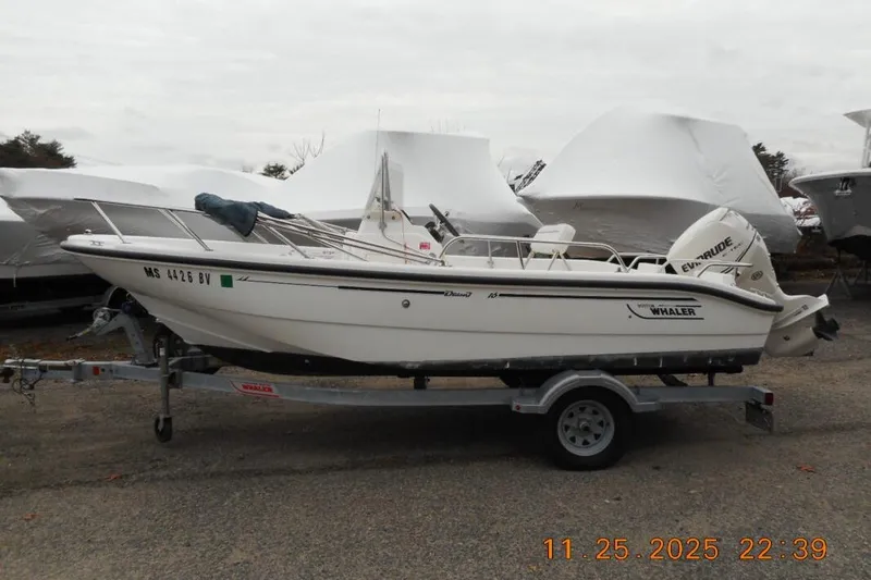 The Image of 2001 Boston Whaler 16 Dauntless boat on trailer, parked outdoors. - 1