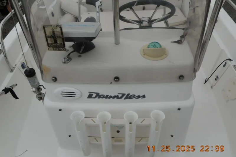 Slide: The Image of 2001 Boston Whaler 16 Dauntless boat console with steering wheel and rod holders. - 4