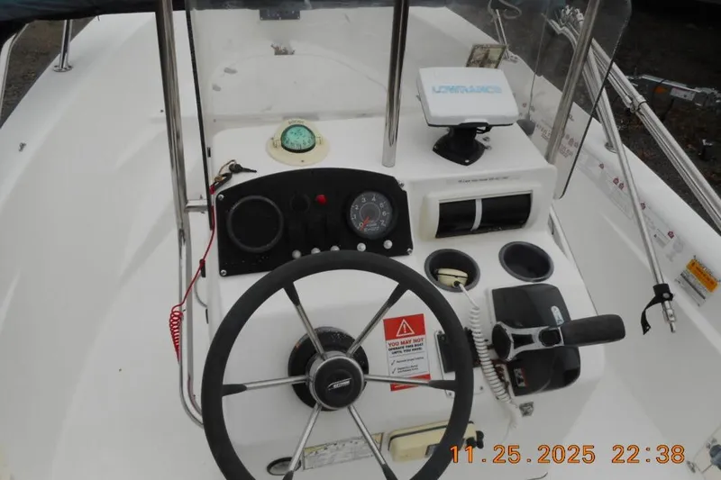 Slide: The Image of 2001 Boston Whaler 16 Dauntless boat dashboard with steering wheel and navigation instruments. - 6