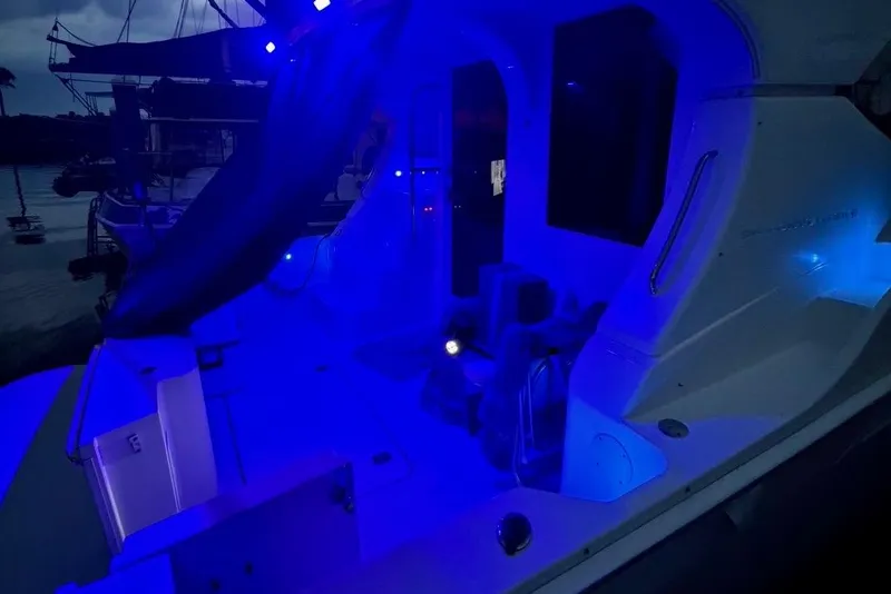 Slide: The Image of 2007 Silverton 36 Convertible yacht illuminated with blue lights at night. - 24