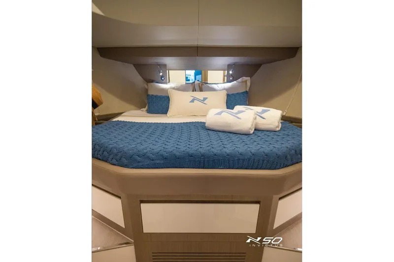 Slide: The Image of Luxurious cabin interior of 2025 NX Boats NX50 Invictus HT with blue bedding. - 12