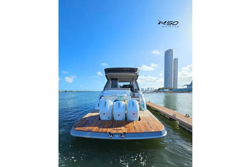 Slide: The Image of 2025 NX Boats NX50 Invictus HT docked, showcasing sleek design and powerful engines. - 14
