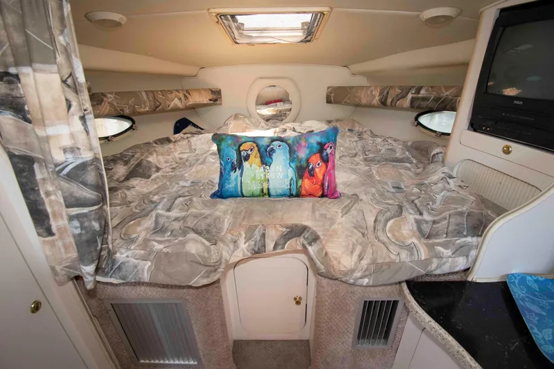 Slide: The Image of Cozy cabin interior of 2000 Rinker Fiesta Vee 310 with colorful parrot pillow. - 12