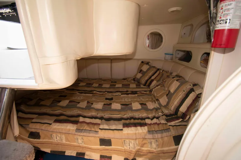 Slide: The Image of Cozy cabin interior of 2000 Rinker Fiesta Vee 310 with patterned bedding. - 13