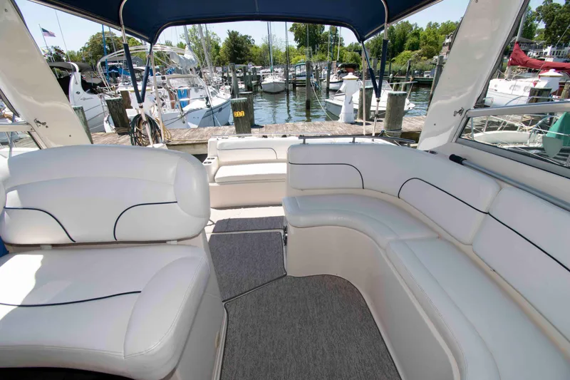 Slide: The Image of Interior of 2000 Rinker Fiesta Vee 310 yacht with white seating at marina. - 3